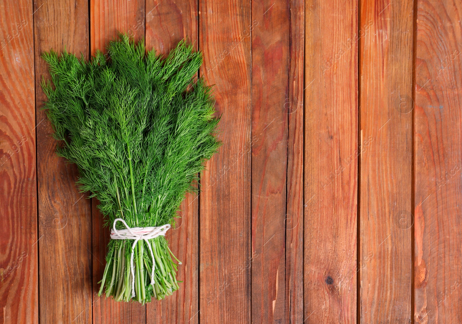 Photo of Bunch of fresh green dill on wooden table, top view. Space for text