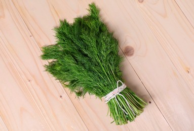 Photo of Bunch of fresh green dill on wooden table, top view