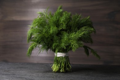 Photo of Bunch of fresh green dill on grey table