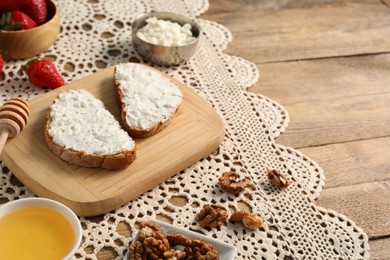 Photo of Delicious ricotta bruschettas and products on wooden table. Space for text