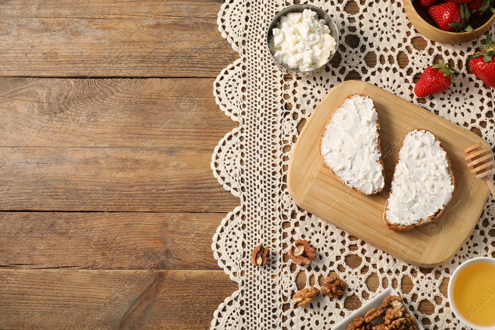 Photo of Delicious ricotta bruschettas and products on wooden table, flat lay. Space for text