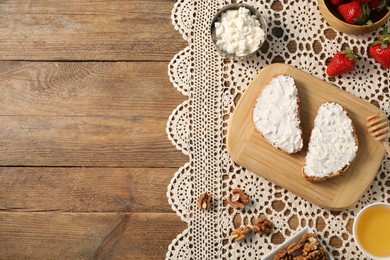 Photo of Delicious ricotta bruschettas and products on wooden table, flat lay. Space for text