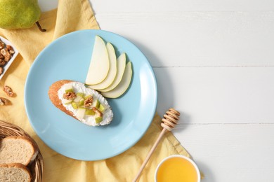 Photo of Delicious ricotta bruschetta with pear and walnut served on white wooden table, flat lay. Space for text