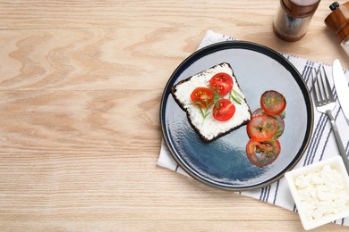 Photo of Delicious ricotta bruschetta with sliced tomatoes and dill on wooden table, flat lay. Space for text