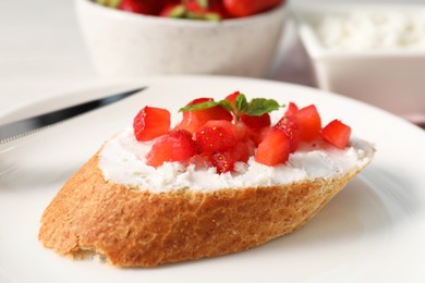 Photo of Delicious ricotta bruschetta with strawberry and mint on plate, closeup