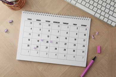 Photo of Timetable. Calendar, stationery and keyboard on wooden table, flat lay