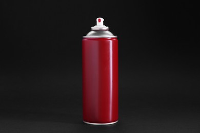 Photo of Red spray paint can on dark gray background