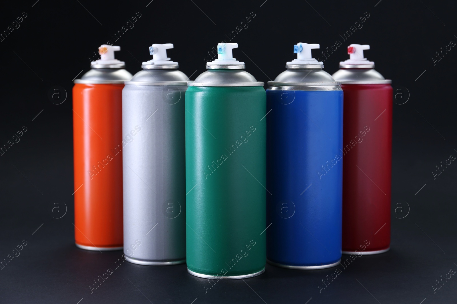 Photo of Many spray paint cans on dark gray background