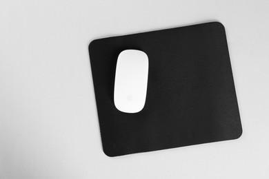 Wireless mouse and mousepad on white background, top view