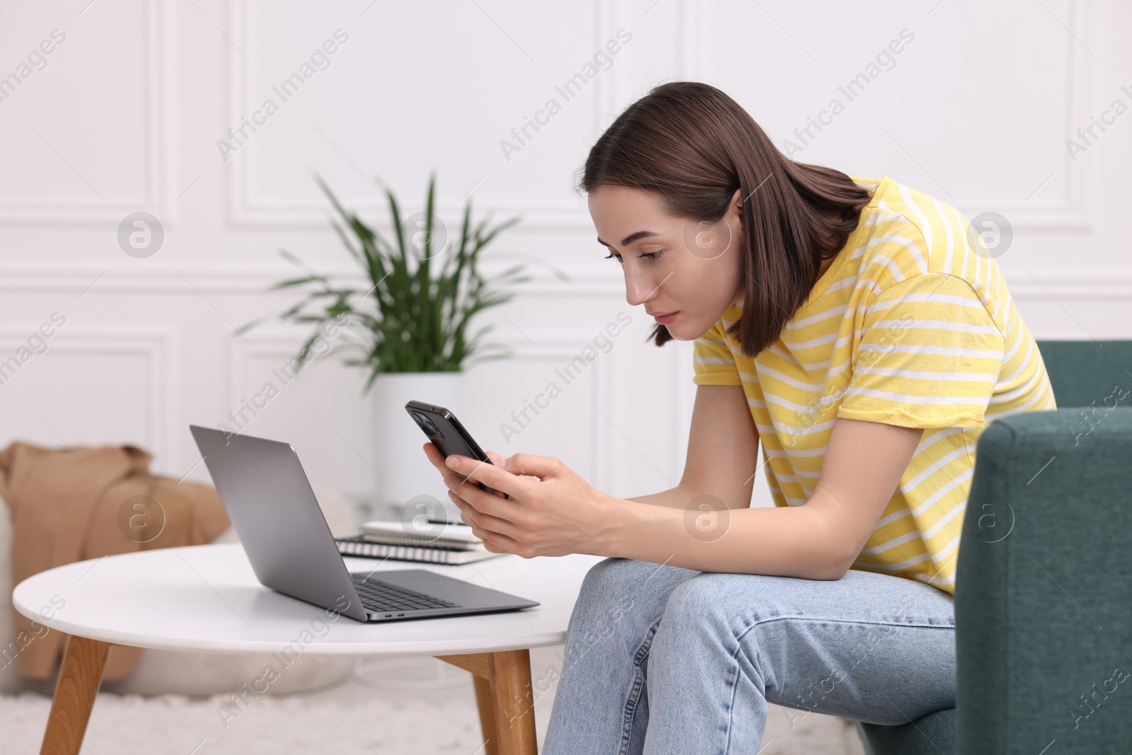 Photo of Woman with poor posture using smartphone at home