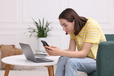 Woman with poor posture using smartphone at home