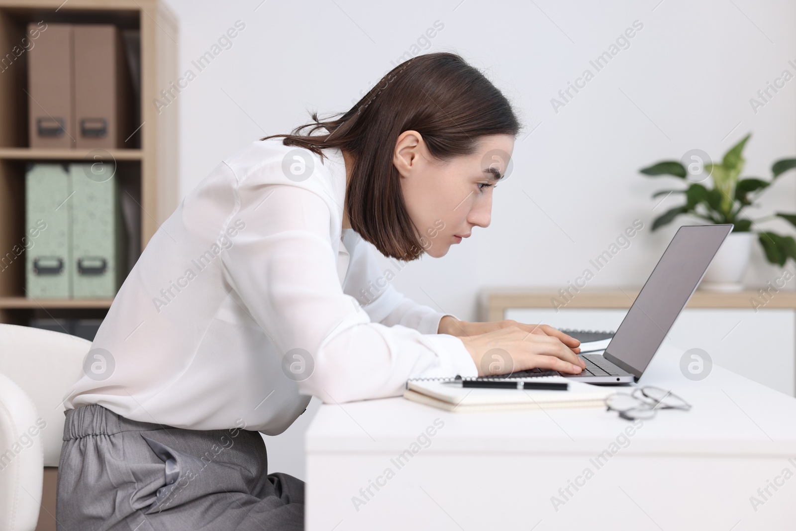 Photo of Woman with poor posture working in office