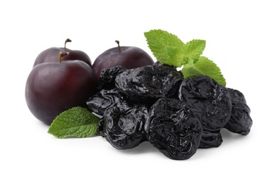 Delicious prunes, fresh ripe plums and mint isolated on white