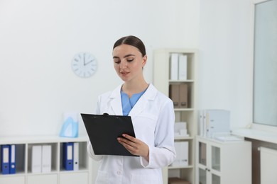 Photo of Professional receptionist with clipboard working in hospital