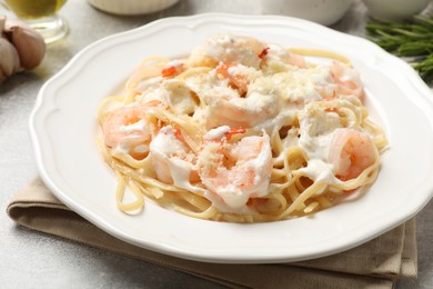 Photo of Delicious pasta with shrimps served on light table, closeup