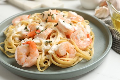 Delicious pasta with shrimps served on white table, closeup