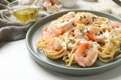 Photo of Delicious pasta with shrimps served on white table, closeup