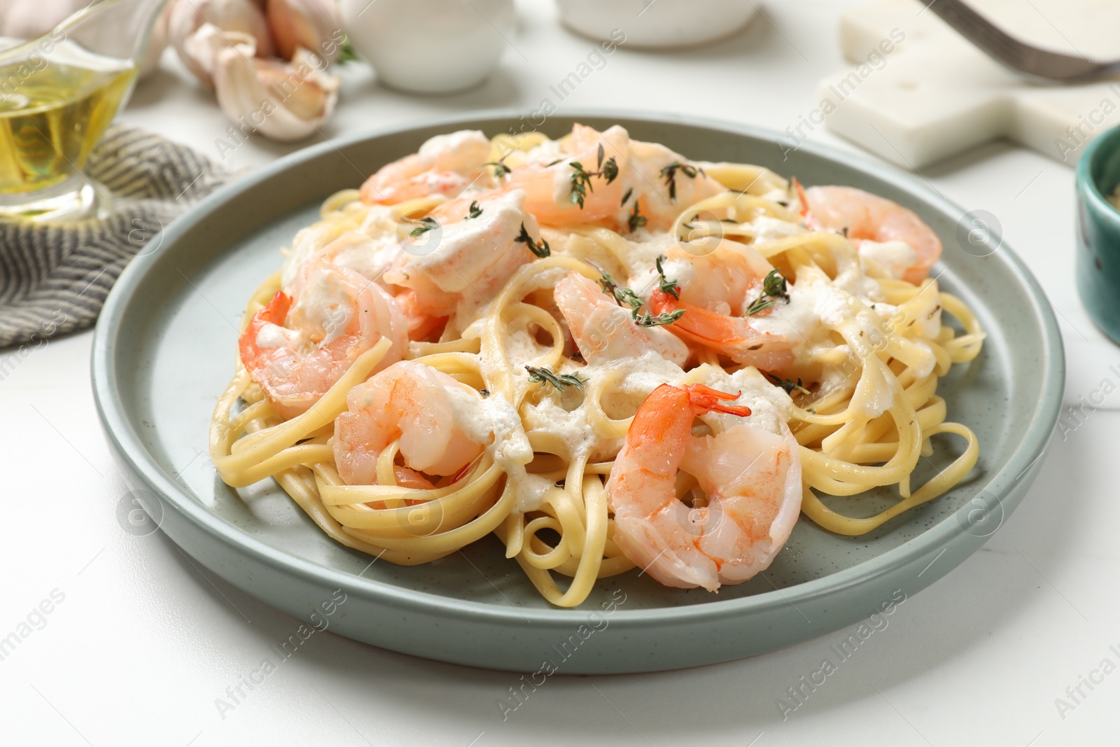 Photo of Delicious pasta with shrimps served on white table, closeup