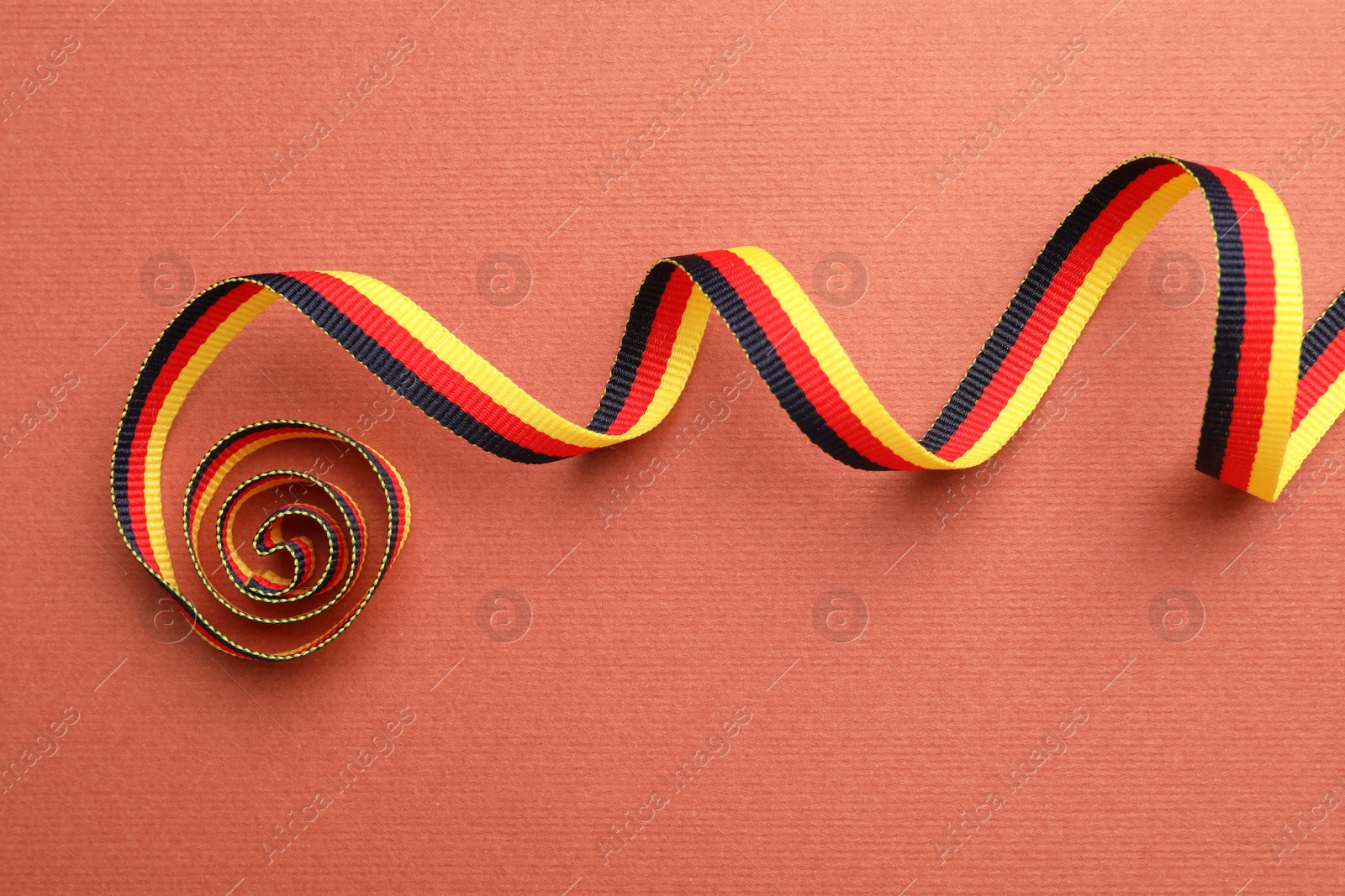 Photo of Ribbon in colors of German flag on color background, top view