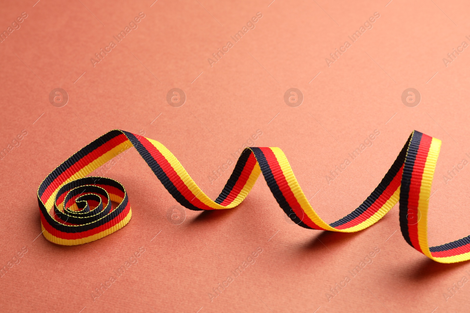 Photo of Ribbon in colors of German flag on color background