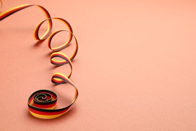 Photo of Ribbon in colors of German flag on color background. Space for text