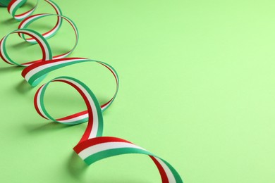 Ribbon in colors of Hungarian flag on green background. Space for text