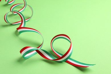 Ribbon in colors of Hungarian flag on green background. Space for text