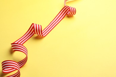 Striped ribbon on yellow background. Space for text