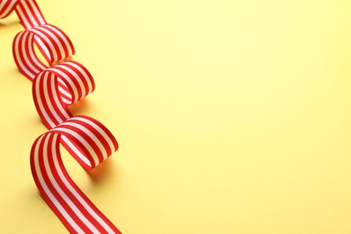 Photo of Striped ribbon on yellow background. Space for text