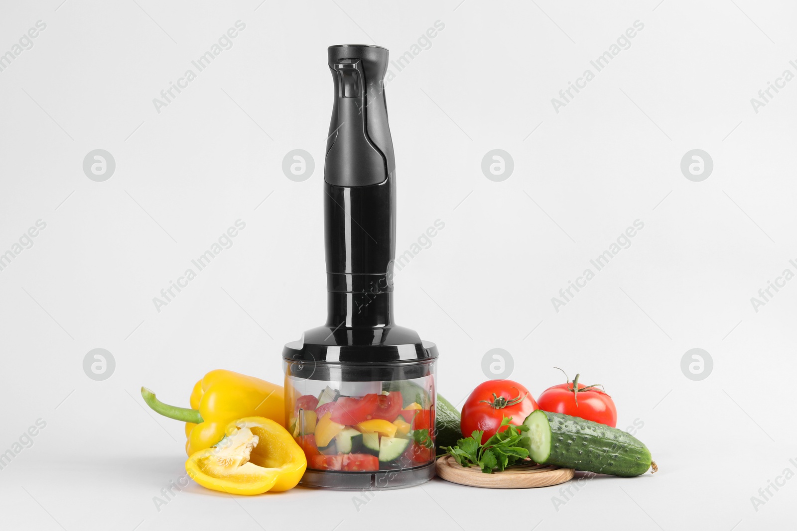 Photo of Hand blender kit, fresh vegetables and parsley on white background