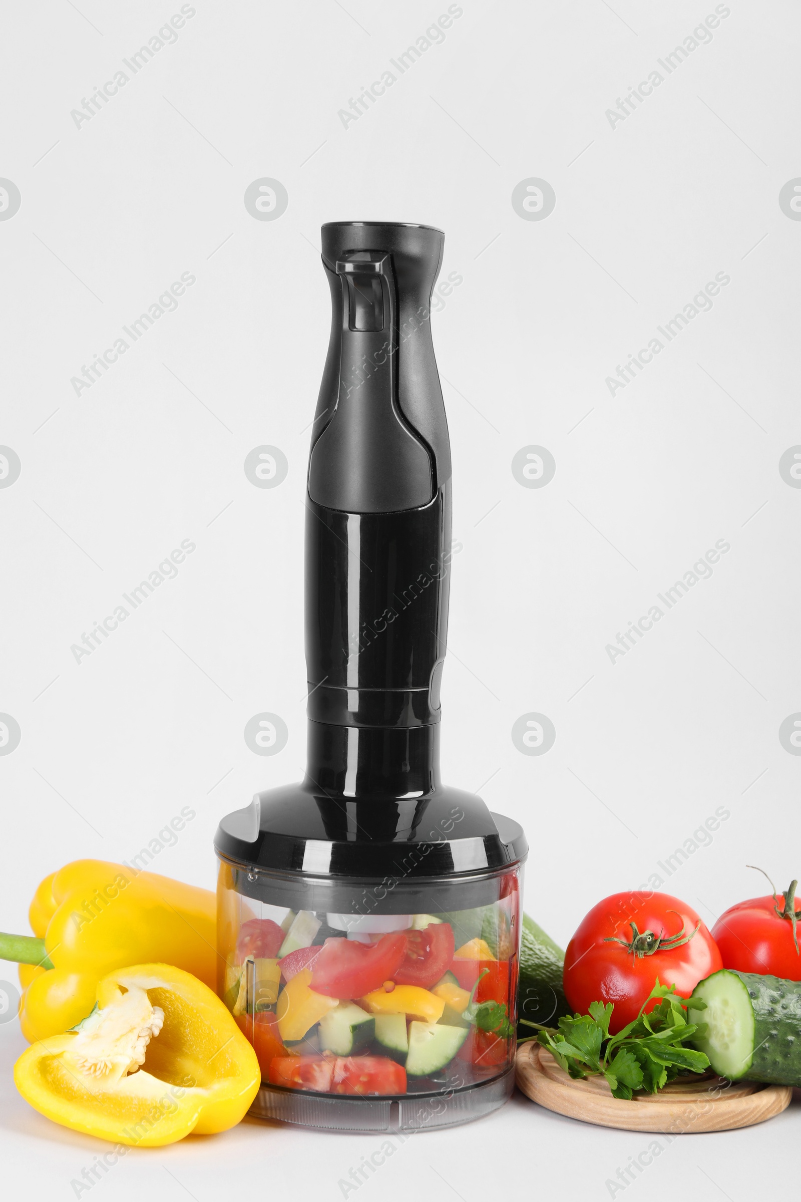 Photo of Hand blender kit, fresh vegetables and parsley on white background