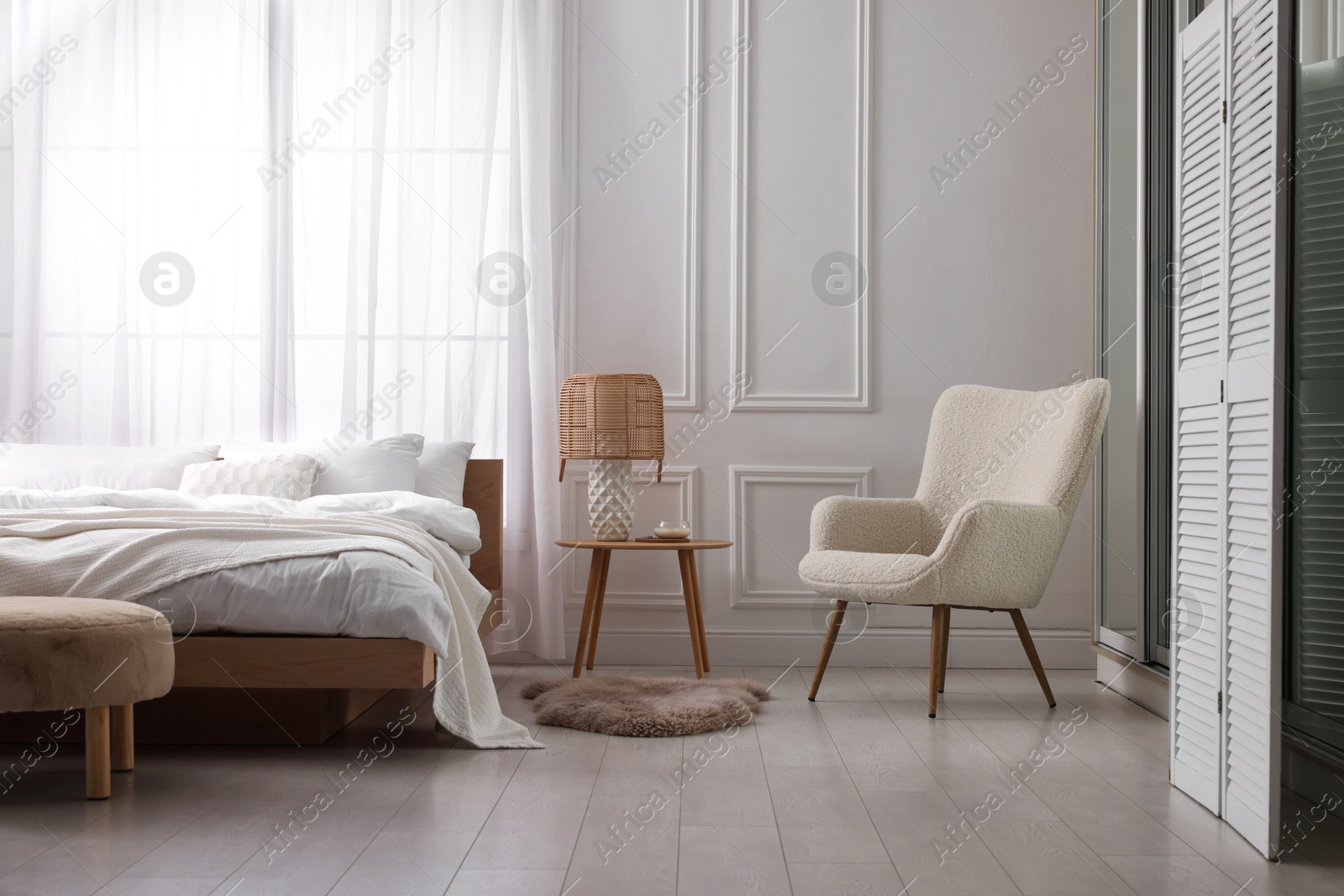 Photo of Stylish living room interior with bed, bedside table and lamp