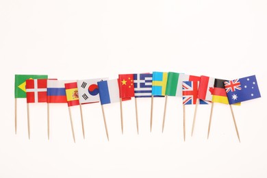 Small paper flags of different countries isolated on white