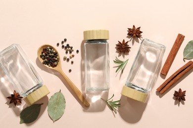 Different spices and glass jars on beige background, flat lay