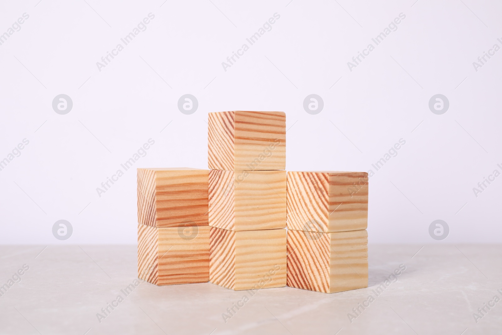 Photo of Wooden cubes on light table against white background