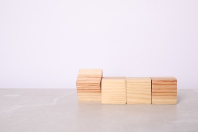 Photo of Wooden cubes on light table against white background. Space for text