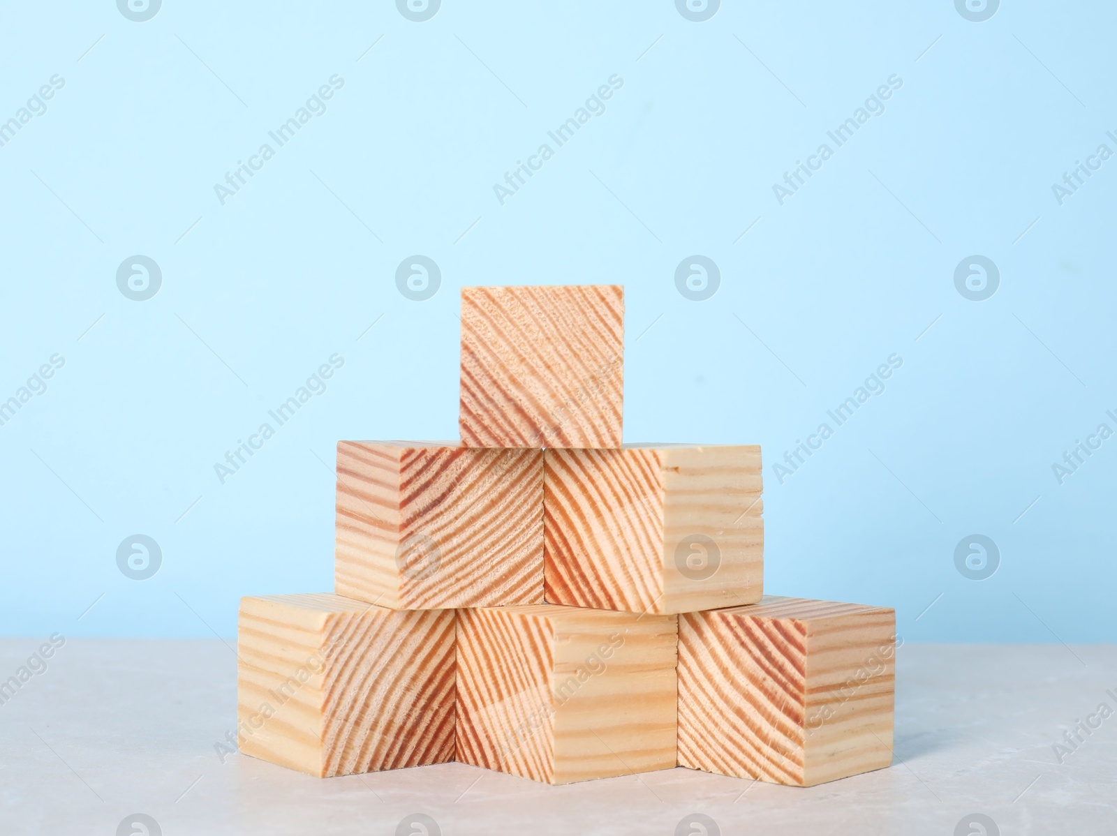 Photo of Wooden cubes on table against light blue background