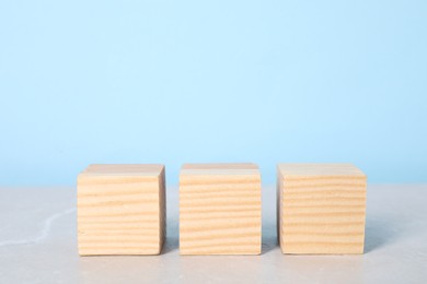 Photo of Wooden cubes on table against light blue background