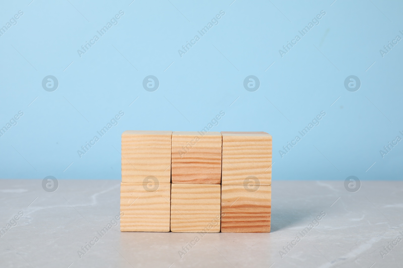 Photo of Wooden cubes on table against light blue background