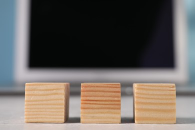 Photo of Wooden cubes on light table against blurred background