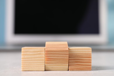 Photo of Wooden cubes on light table against blurred background