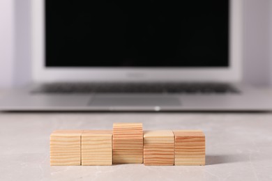 Photo of Wooden cubes on light table against blurred background