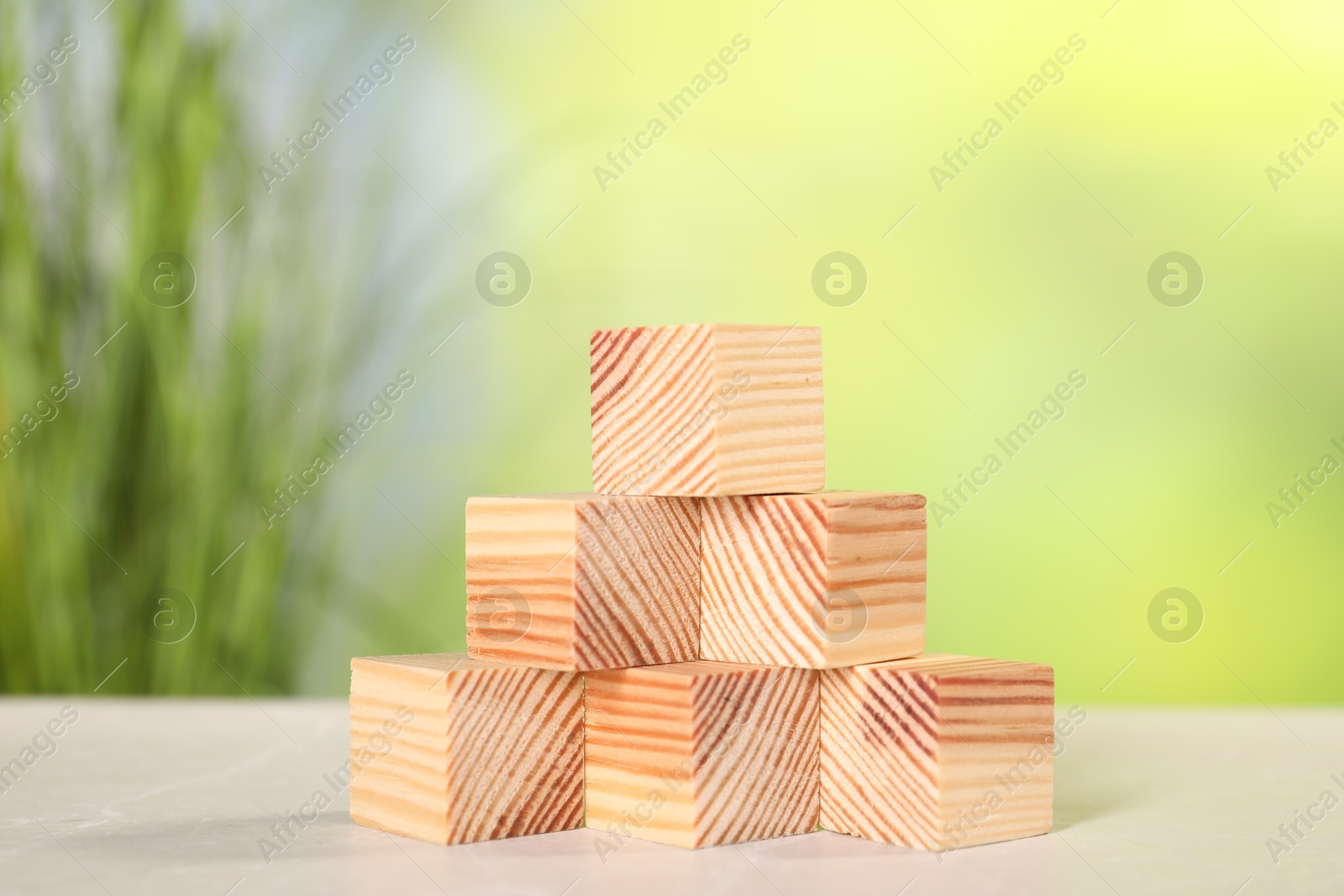 Photo of Wooden cubes on light table against blurred background