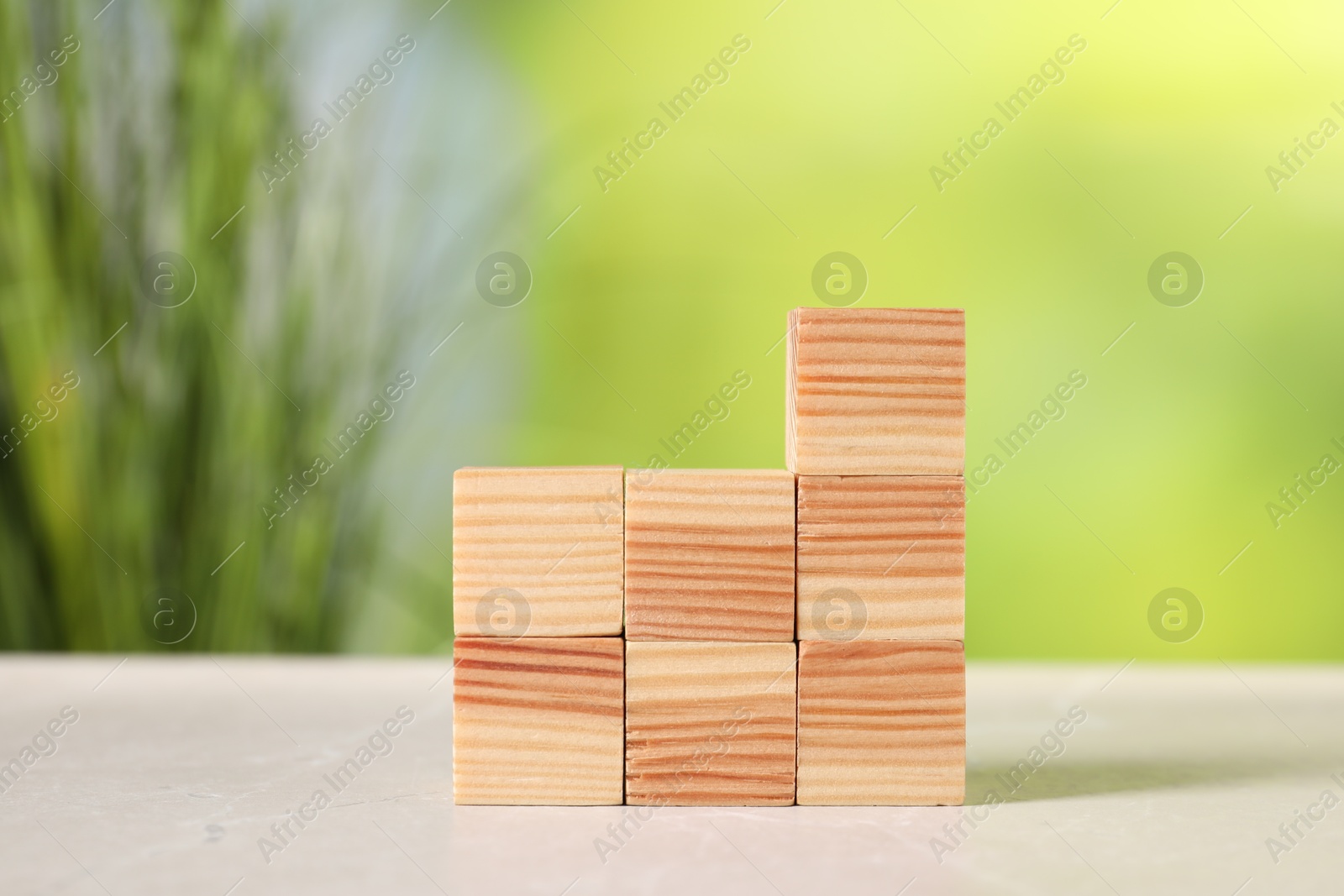 Photo of Wooden cubes on light table against blurred background