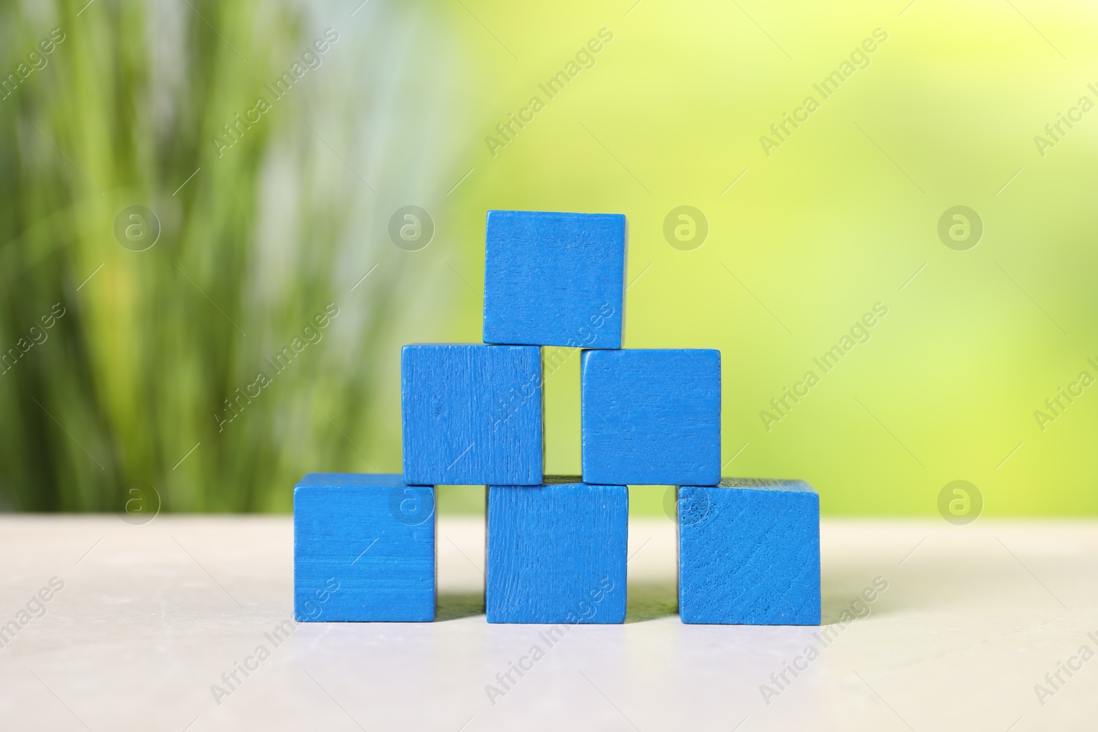 Photo of Blue cubes on light table against blurred background