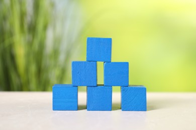 Photo of Blue cubes on light table against blurred background