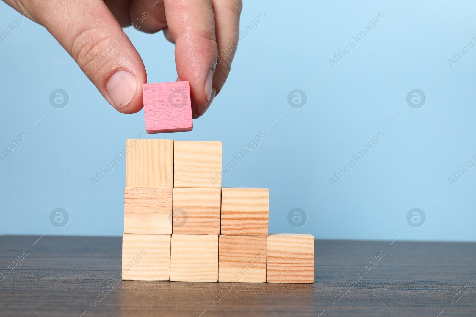 Photo of Woman with wooden cubes at table, closeup