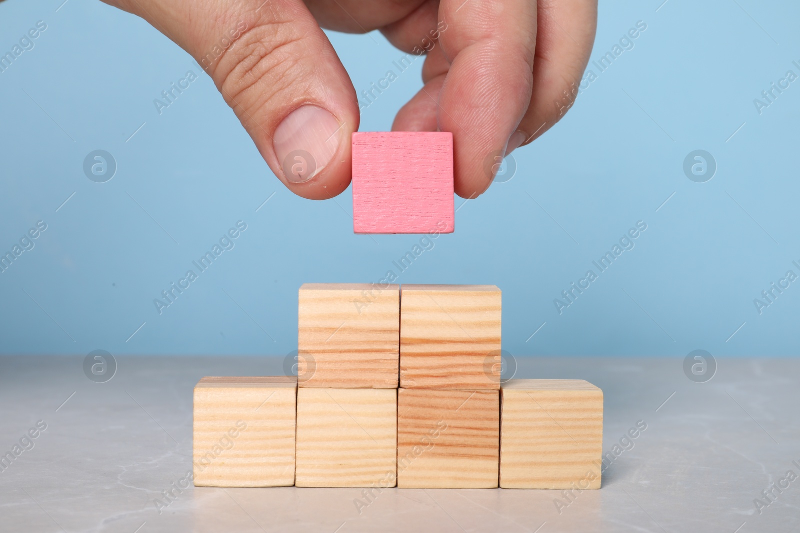 Photo of Woman with wooden cubes at light table, closeup