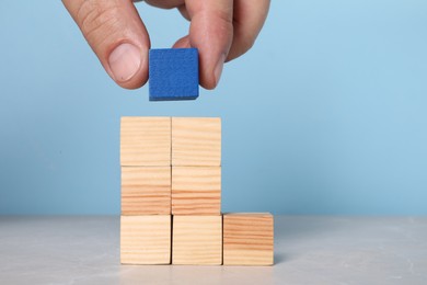 Photo of Woman with wooden cubes at light table, closeup