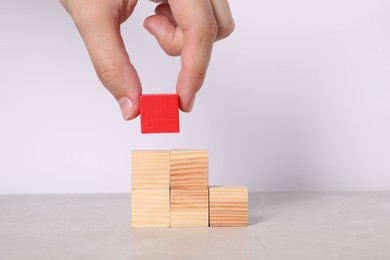 Photo of Woman with wooden cubes at light table, closeup